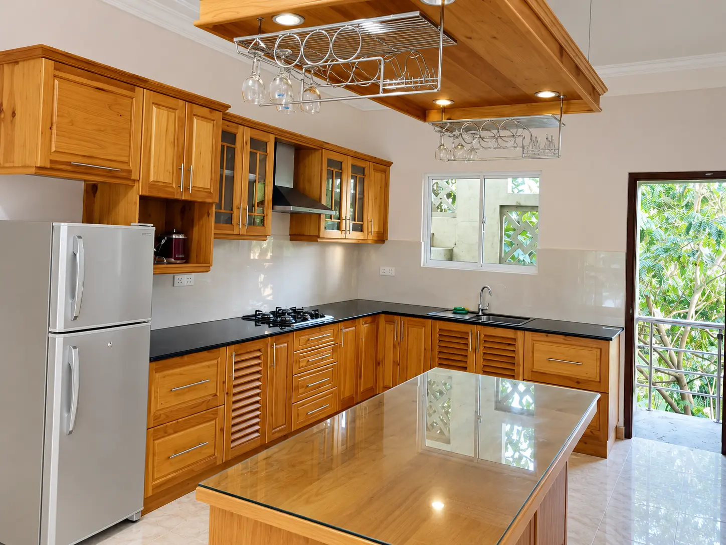Walnut pantry with grey stone counters and patterned backsplash