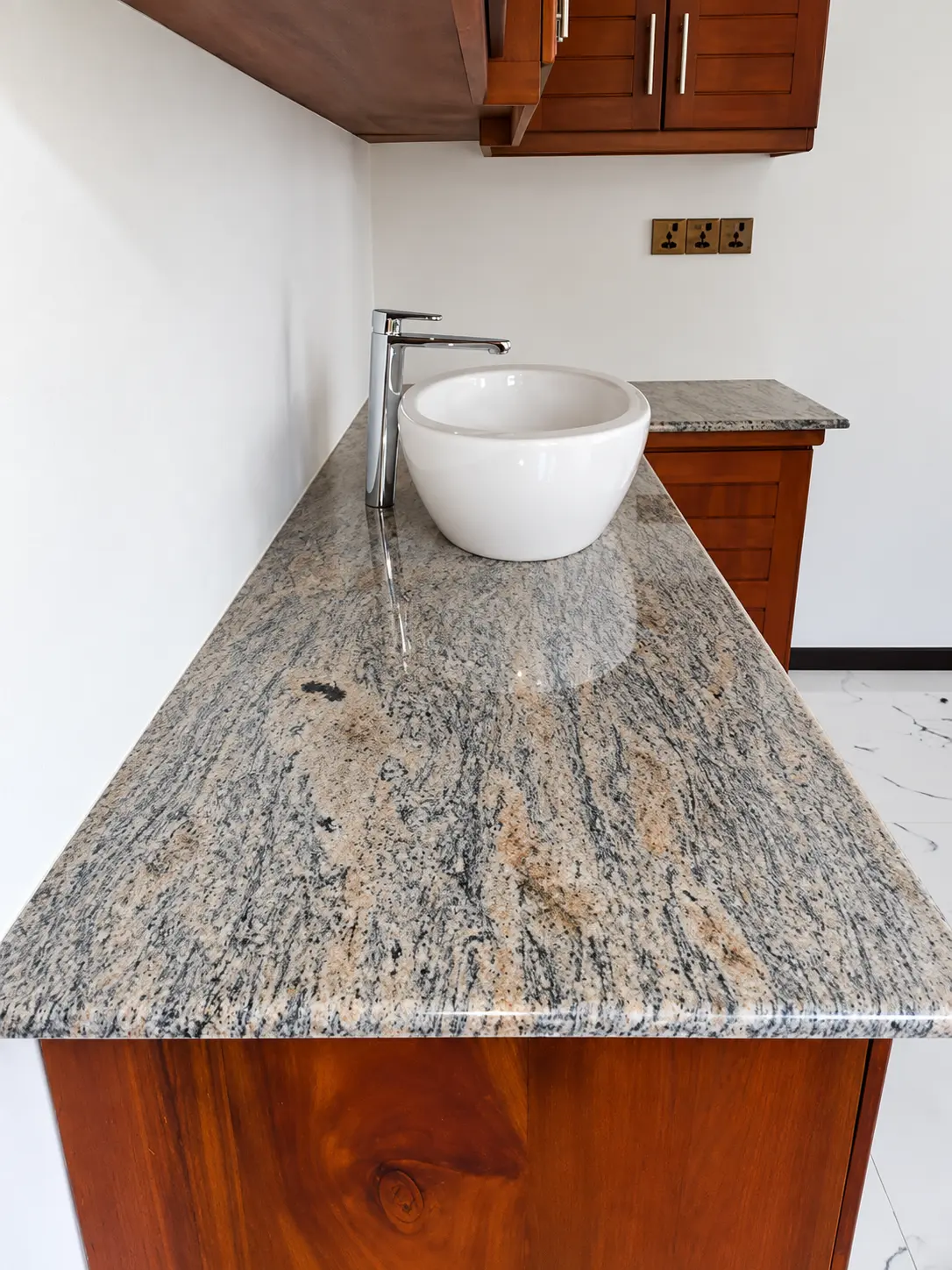 Figured granite vanity top with a white vessel basin