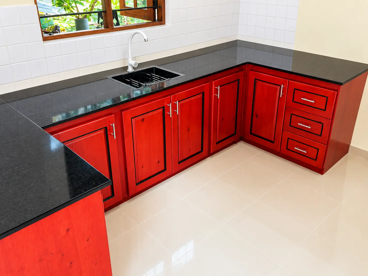 Deep red cabinetry paired with black granite — design concept